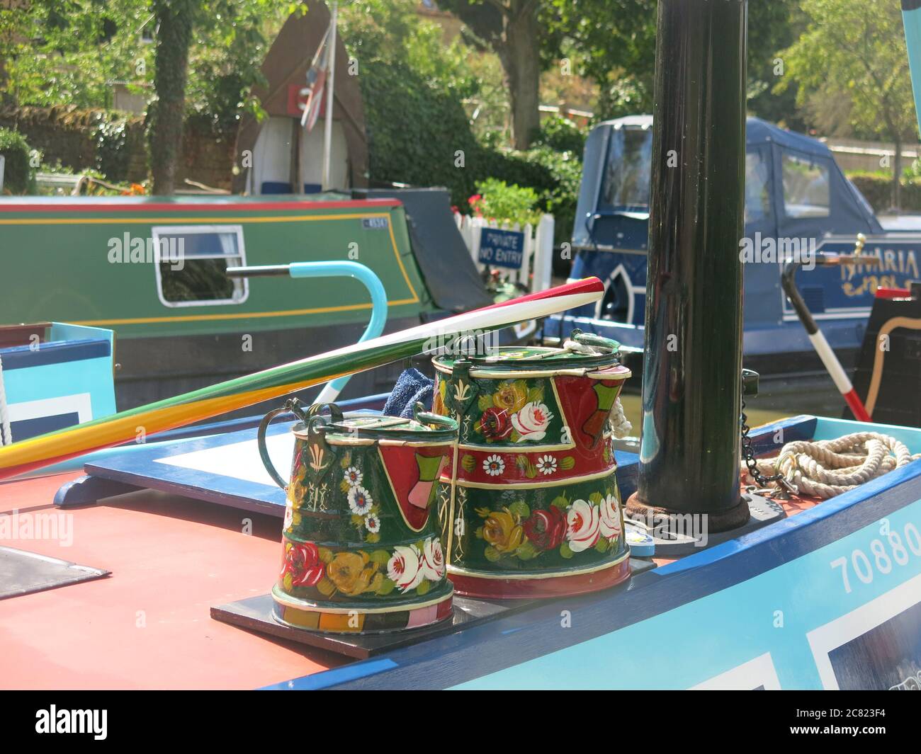 Painted watering cans in typical canal folk art style on a narrowboat on the Grand Union Canal, Northamptonshire. Stock Photo