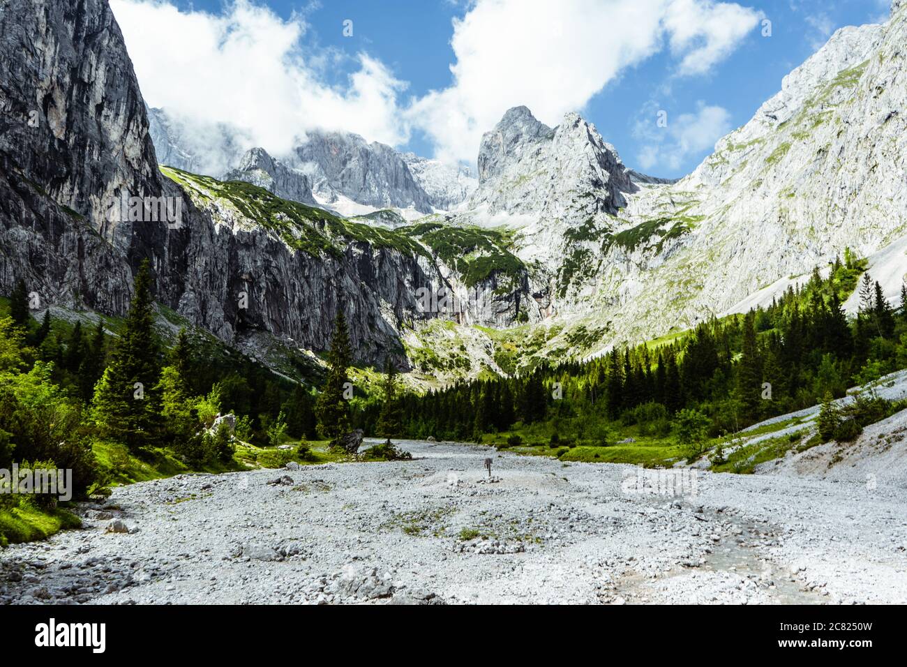 view of a valley in the alps with clouds Stock Photo - Alamy