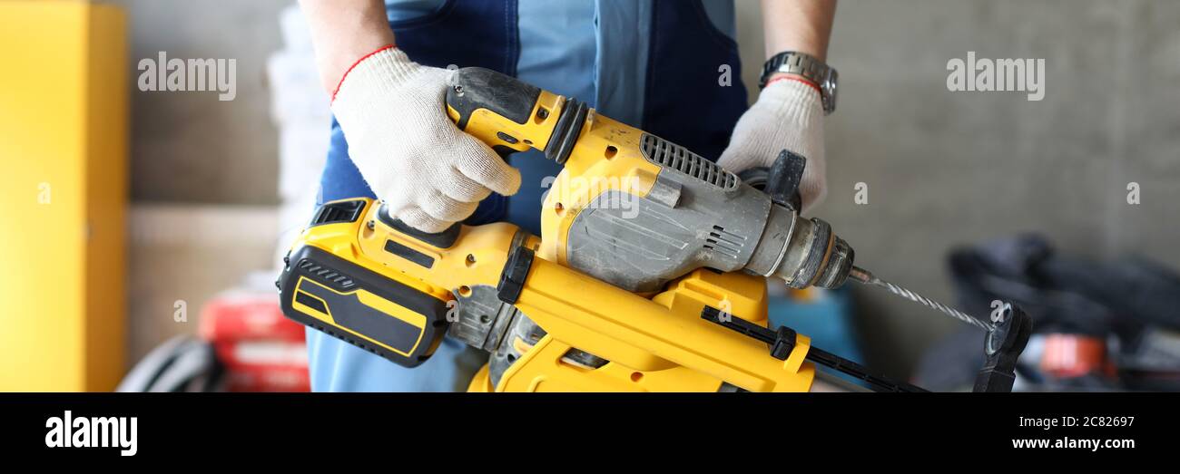 Builder holding perforator instrument in hand Stock Photo