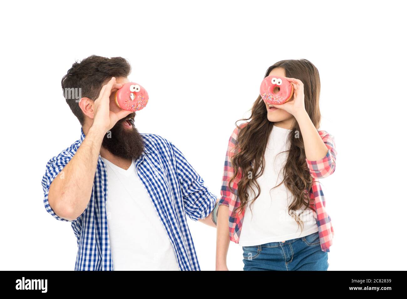 Cheerful family. Sweets and treats concept. Daughter and father eat sweet donuts. Dessert. Happiness and joy. Sweet mood. Bakery shop. Fathers day. Sweet tooth. Girl child and dad hold glazed donuts. Stock Photo