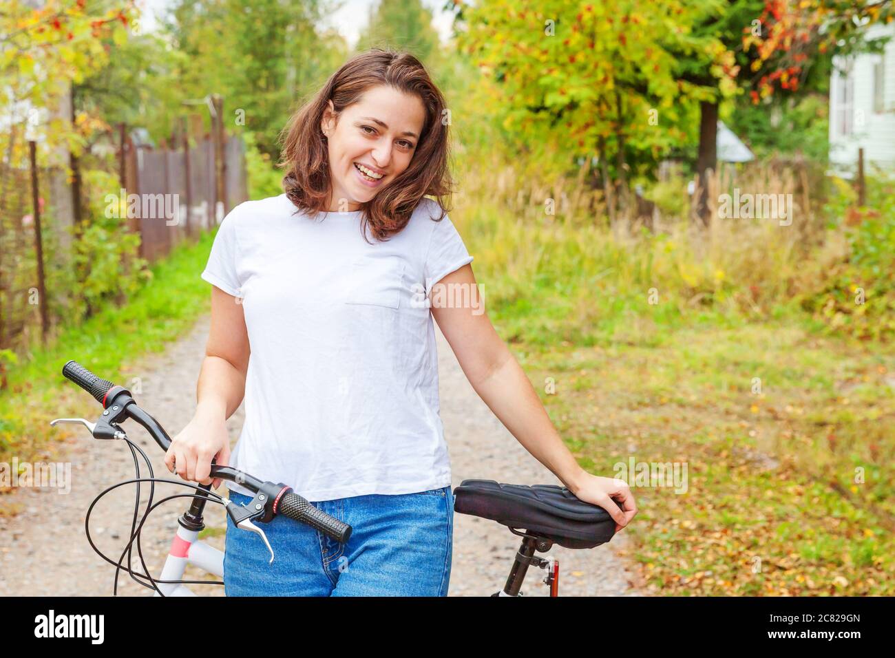 Young woman riding bicycle in summer city park outdoors. Active people. Hipster girl relax and rider bike. Cycling to work at summer day. Bicycle and ecology lifestyle concept Stock Photo