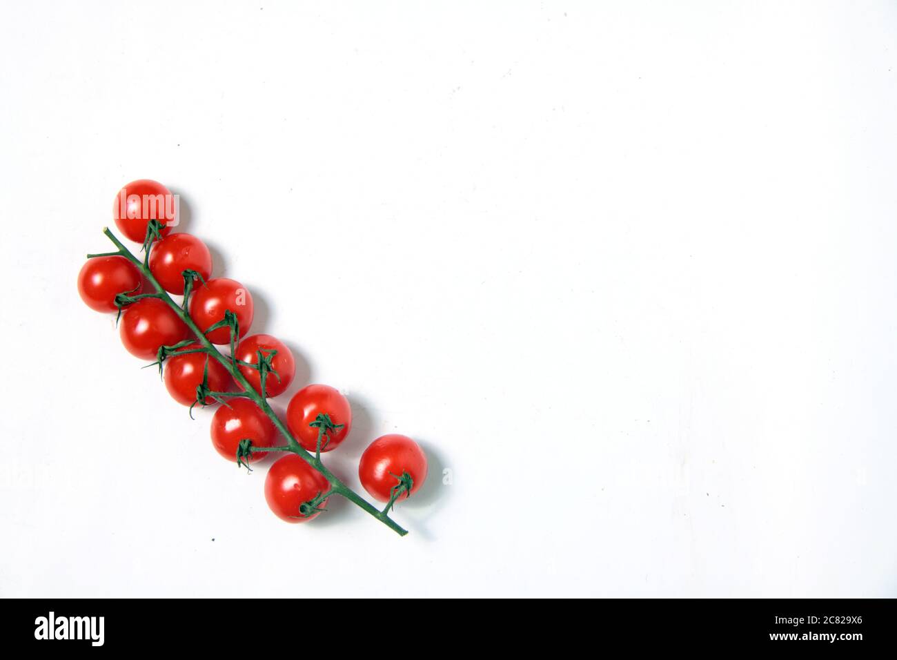 a branch of cherry tomatoes isolated on white background flat lay ...