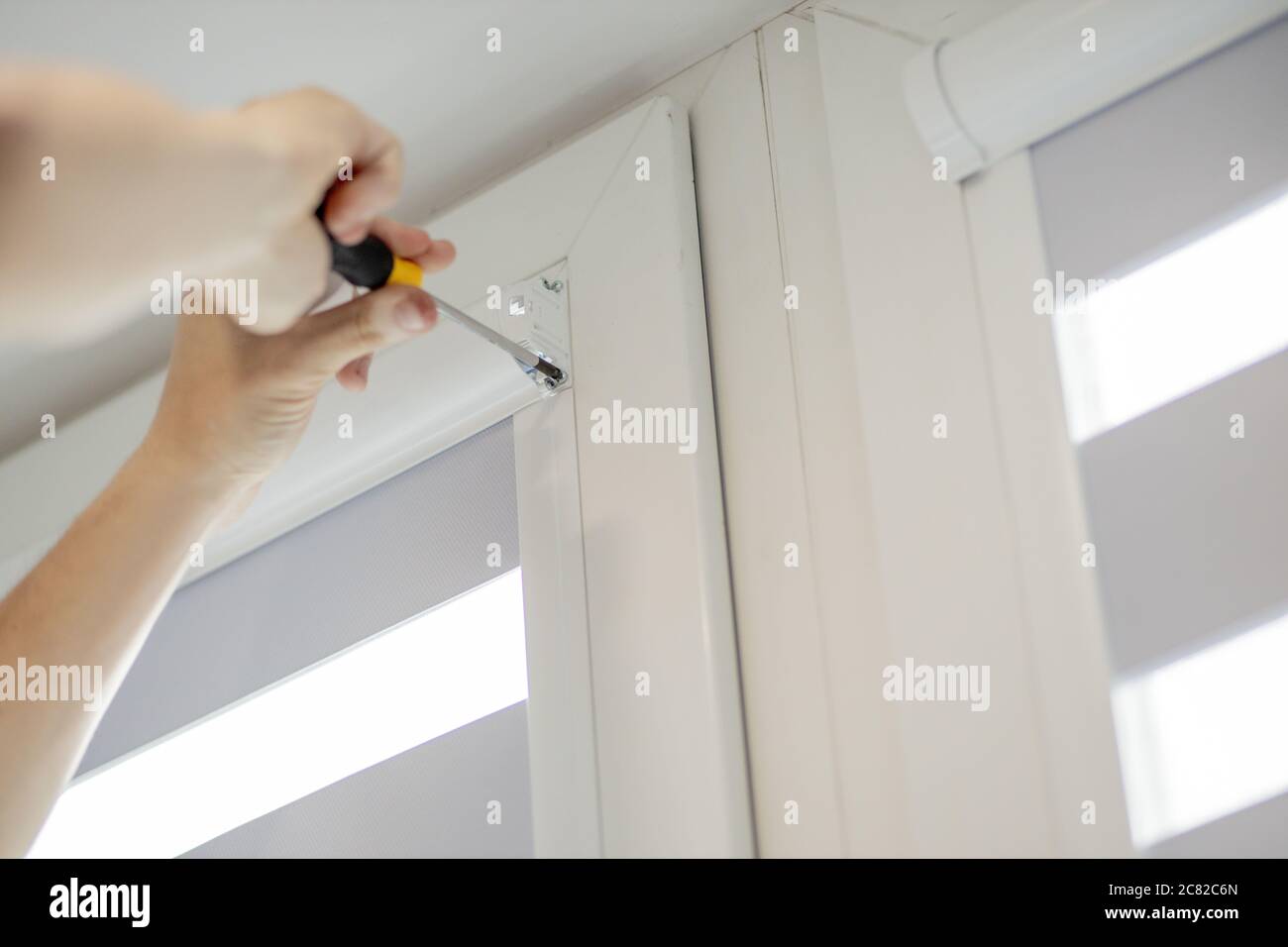 Man installing cassette roller blinds on windows Stock Photo