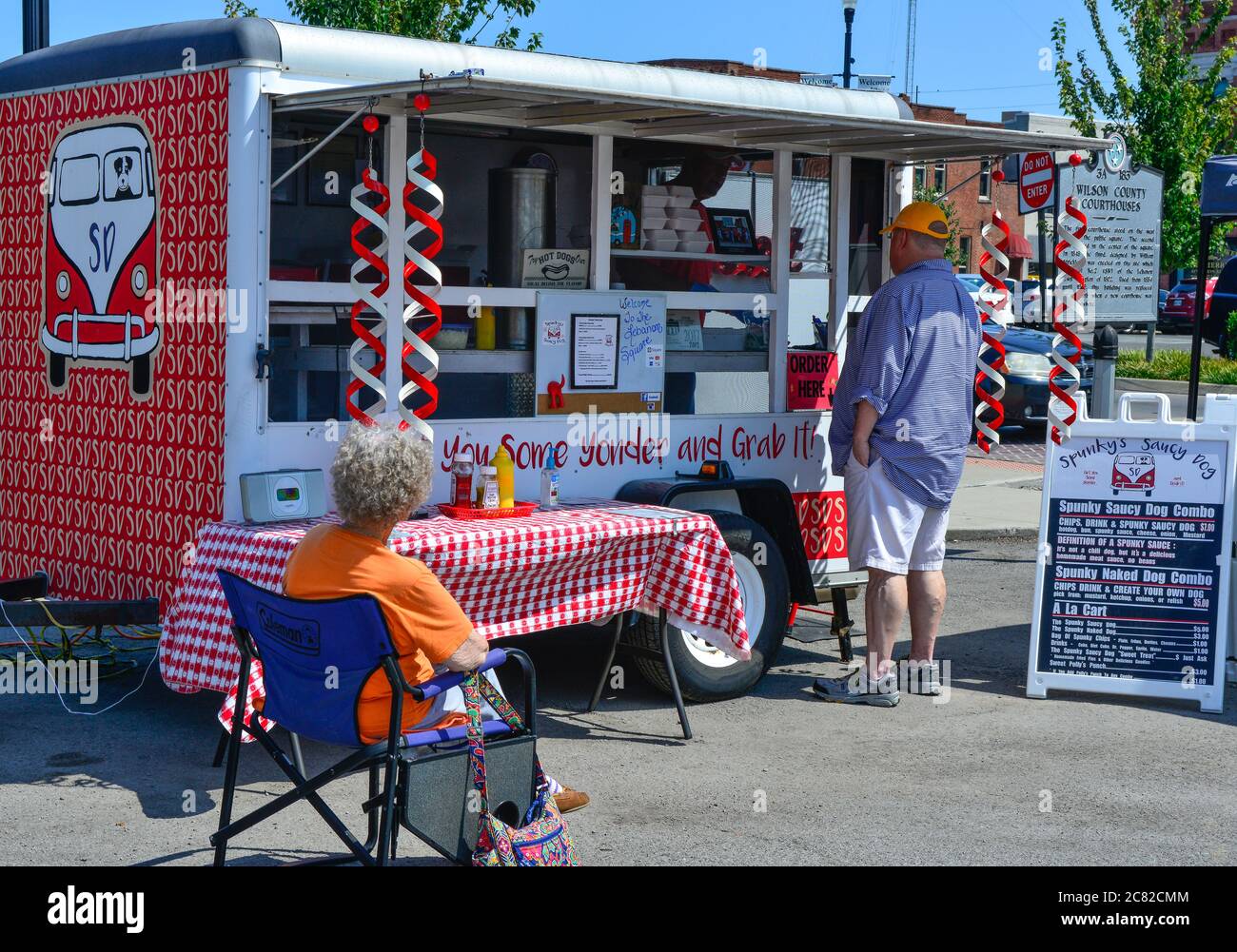 A Hot dog vendor in a trailer, the Spunkys Saucy Dog, takes orders from