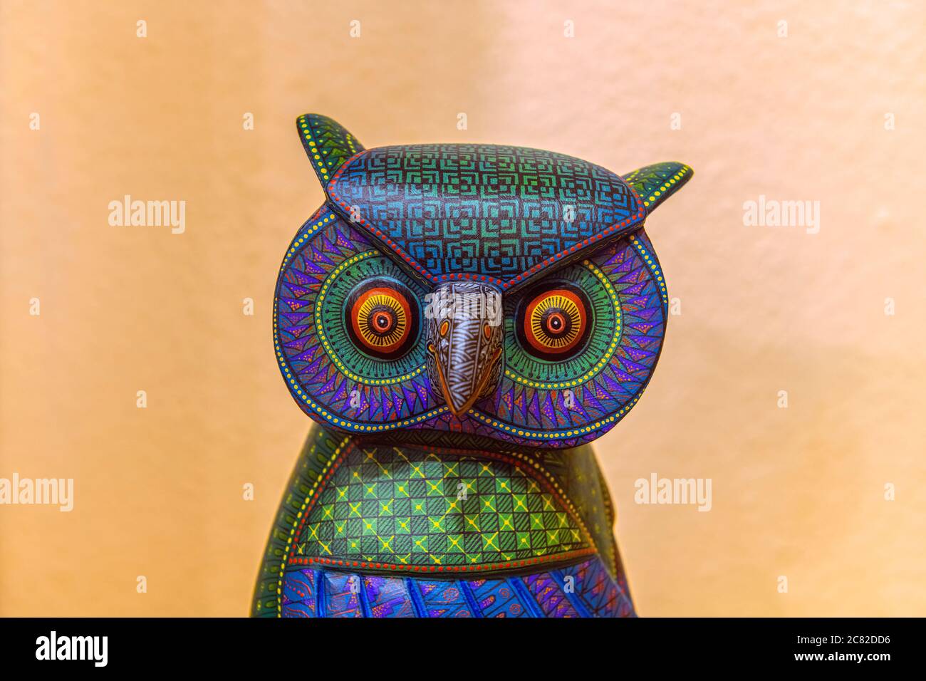 Painted wooden animal carving in the form of an owl known as alebrijes with orange background, Oaxaca, Mexico. Stock Photo