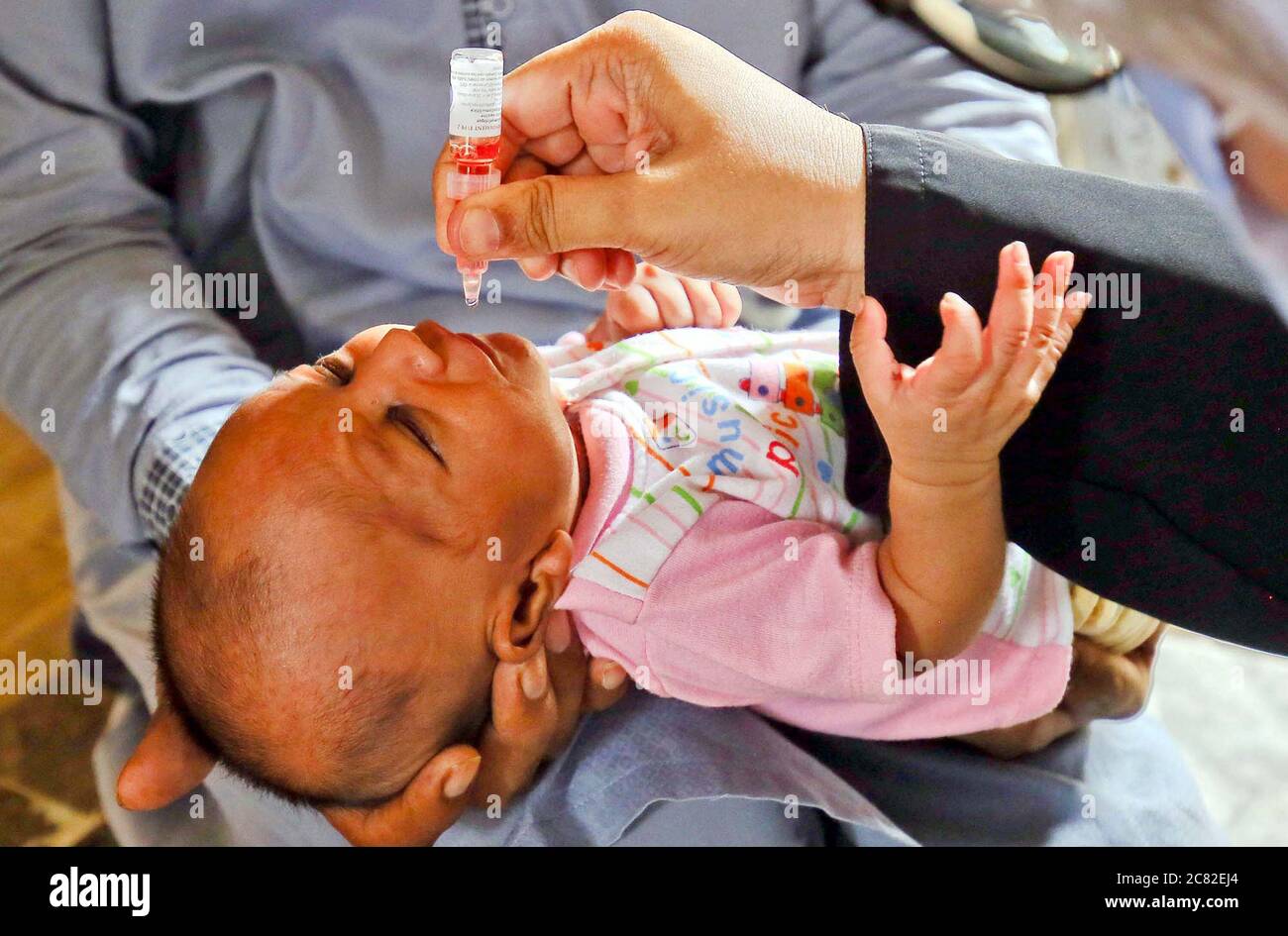 Health worker administrates polio-vaccine drops to a child during anti-polio  immunization campaign located on Nazimabad area of Karachi on Monday, July  20, 2020. A small-scale polio vaccination campaign will kick off in