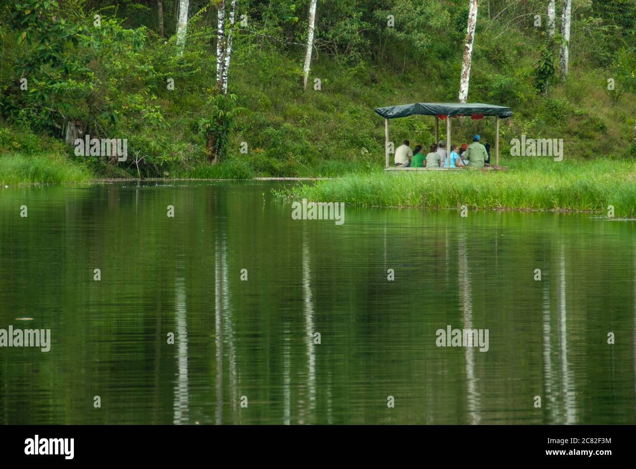 People riding a boat on way to a rainforest. Stock Photo
