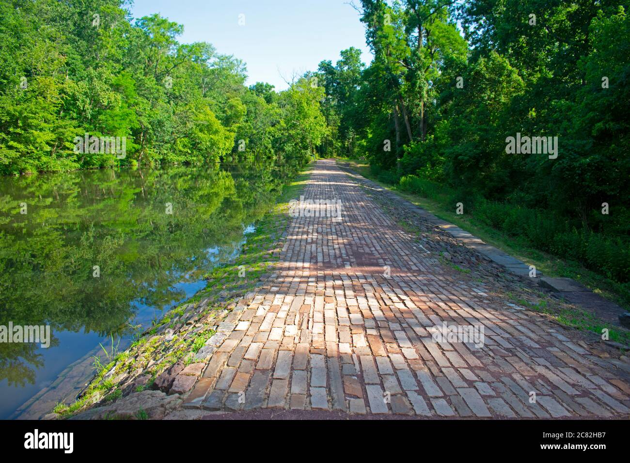 Footpath along the Delaware and Raritan Canal at Colonial Park. This section of the path is paved with brick arranged in parallel lines. -03 Stock Photo