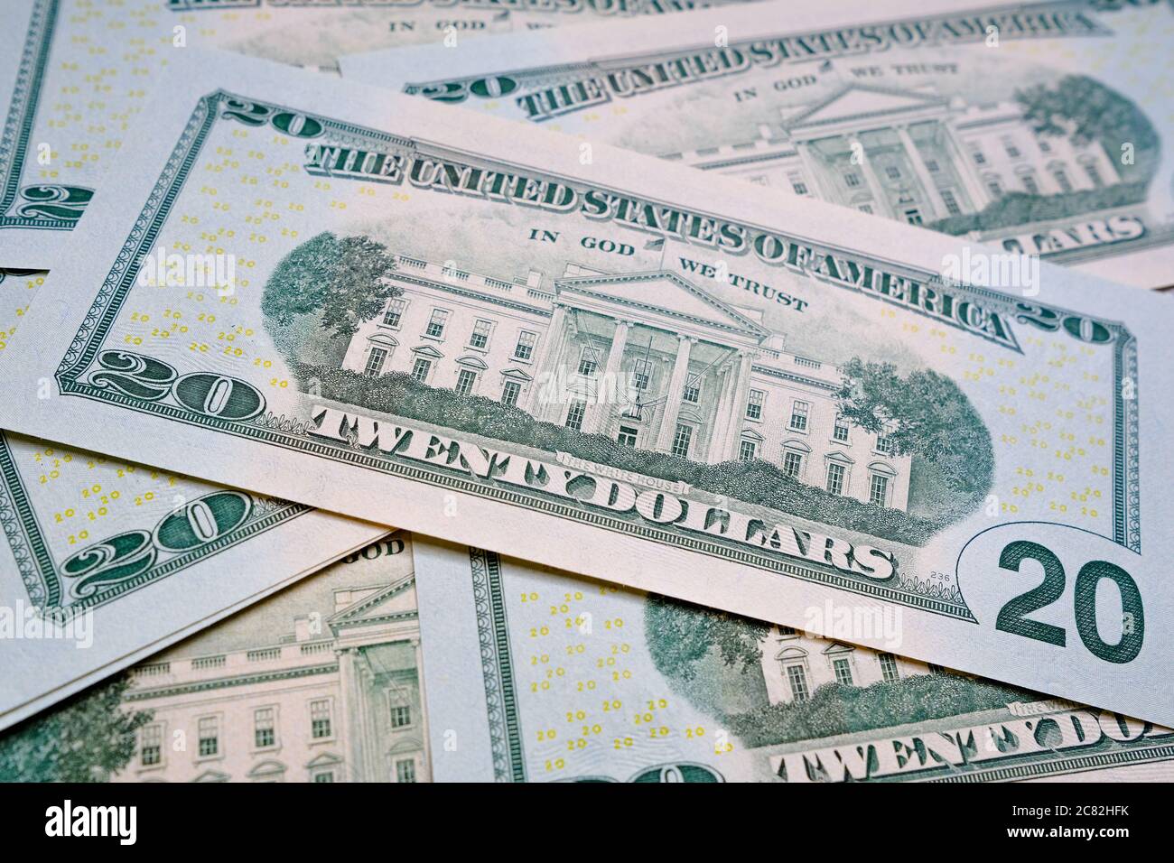 White House seen on 20 US dollars banknote which is placed on top of pile of other cash. Selective focus. Stock Photo