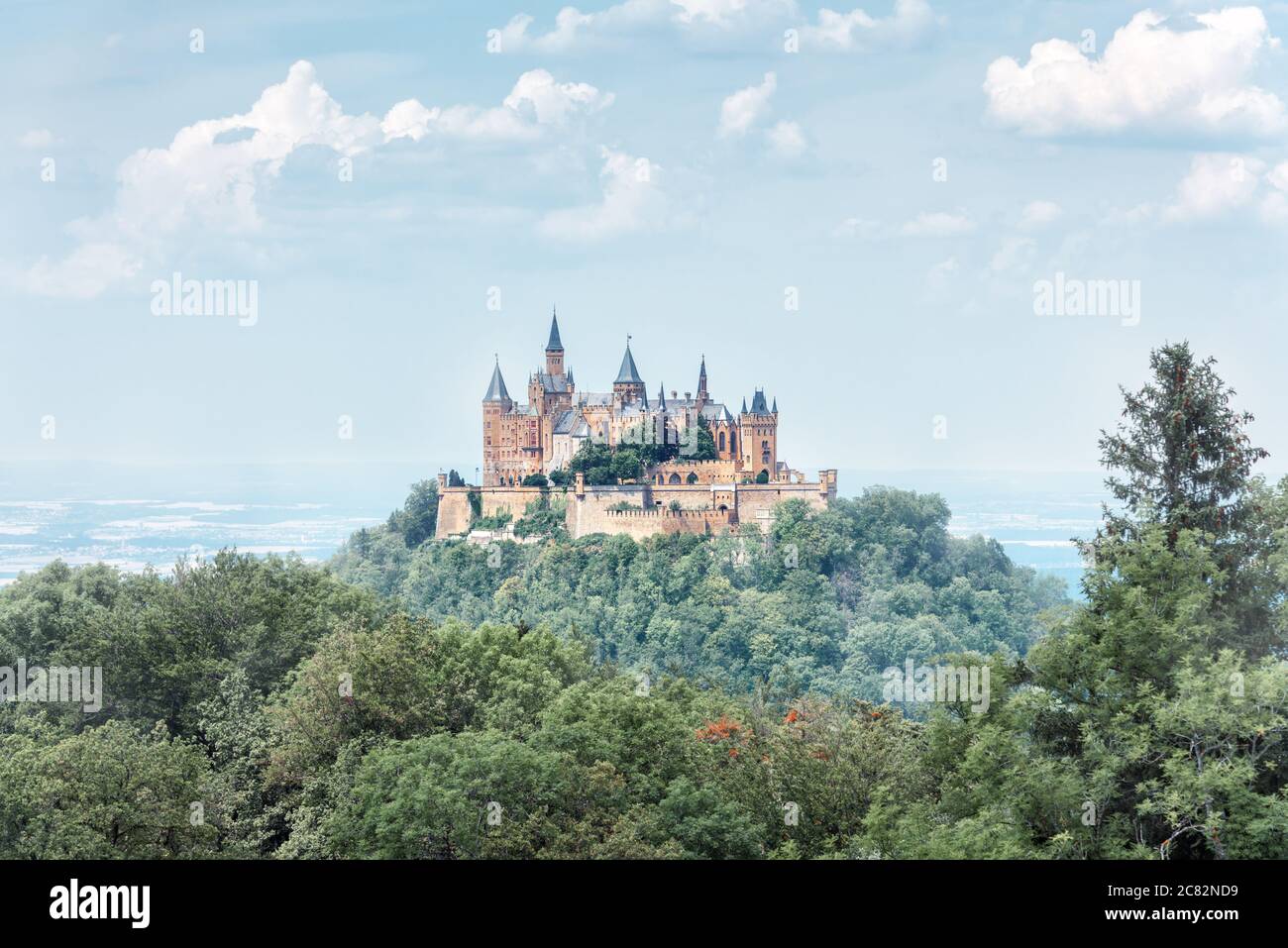 Landscape of misty mountain with Gothic Hohenzollern Castle in summer morning, Germany. Old Burg Hohenzollern is landmark in Stuttgart vicinity. Sceni Stock Photo