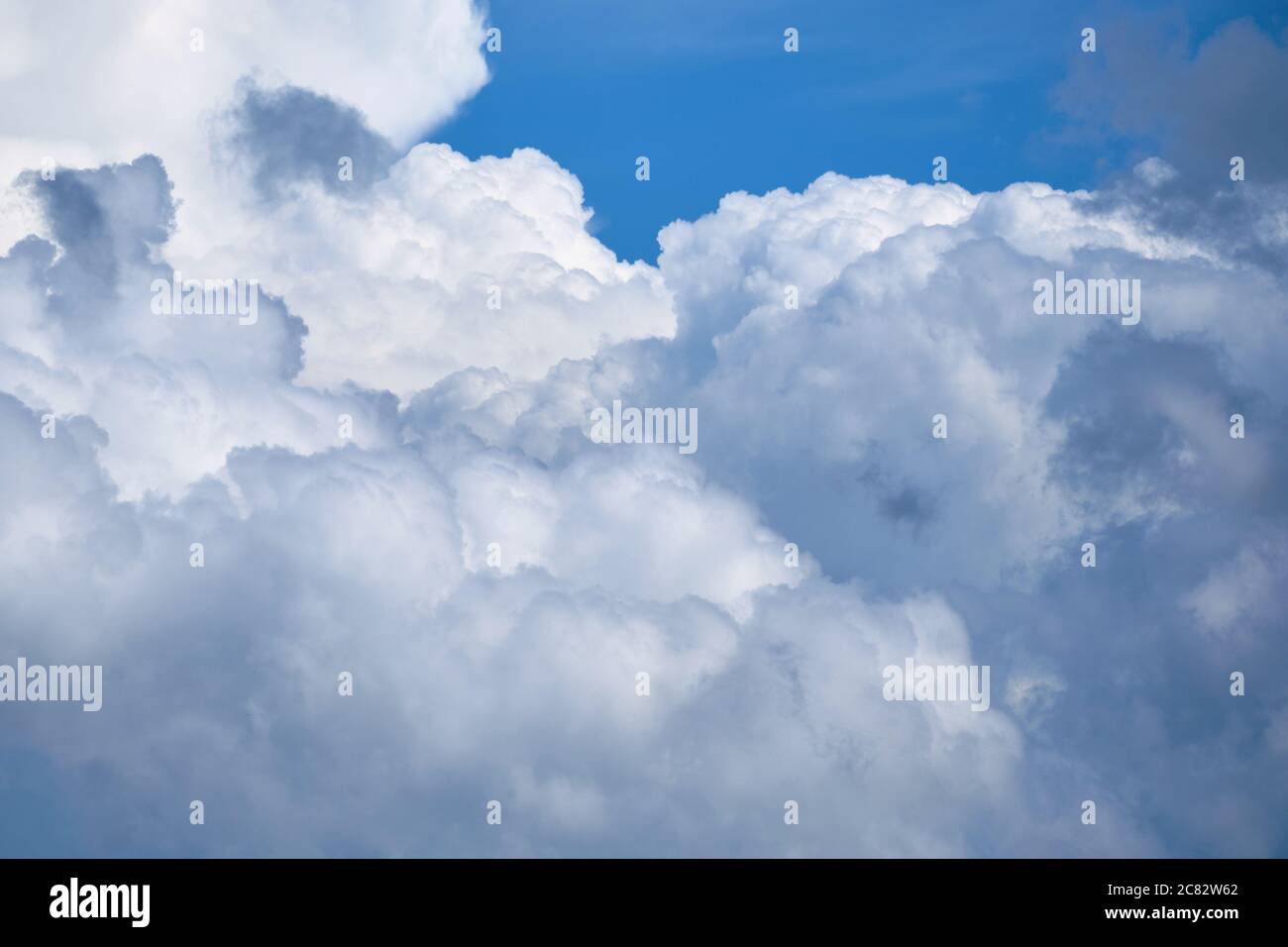 Large white clouds with thunderstorms in the blue sky. Stock Photo