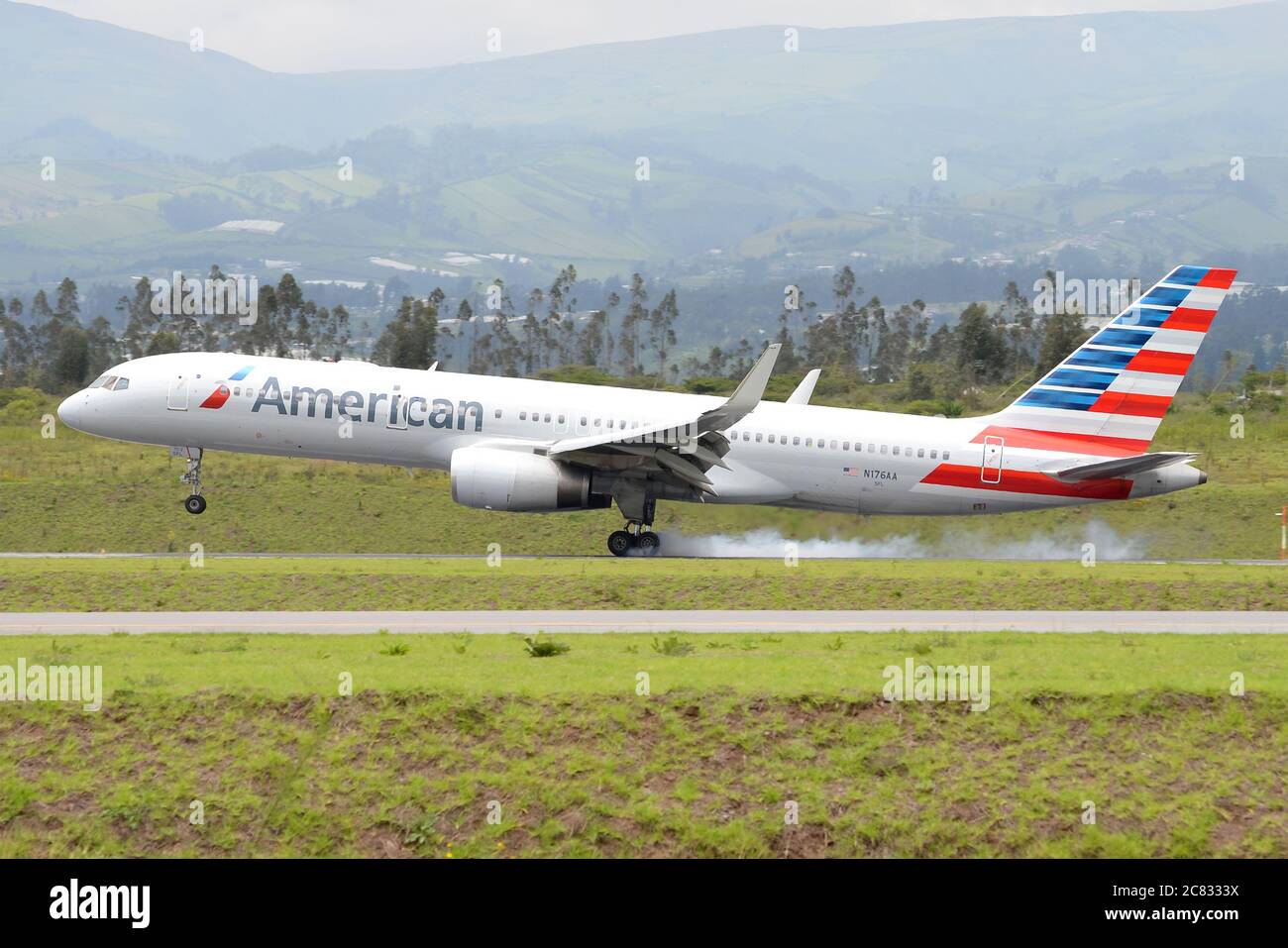 American Airlines Boeing 757 landing at Quito Mariscal Sucre International Airport in Ecuador. N176AA arrival. Airplane main landing gear smoking. Stock Photo
