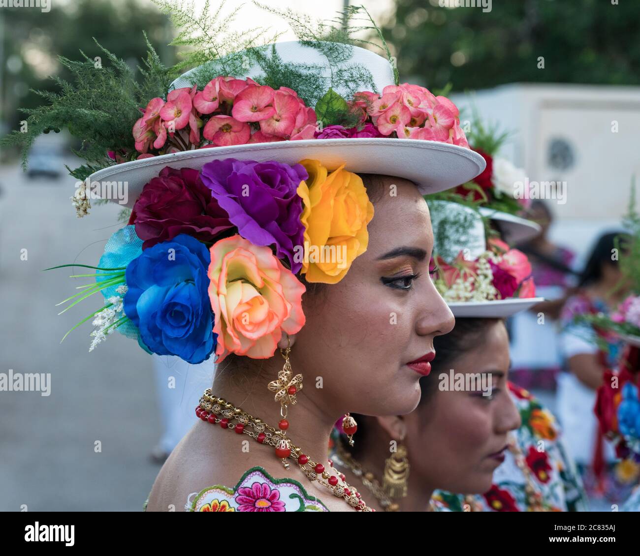 Women in tradtional festive embroidered huipils and flowered hats prepare for the Dance of the Pig's Head and of the Turkey, or Baile de la cabeza del Stock Photo
