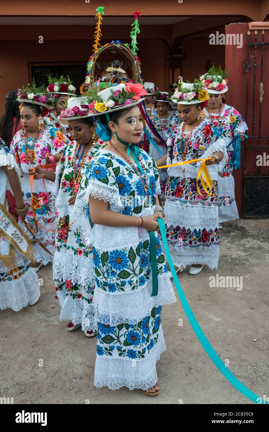 Women in tradtional festive embroidered huipils and flowered hats prepare for the Dance of the Pig's Head and of the Turkey, or Baile de la cabeza del Stock Photo