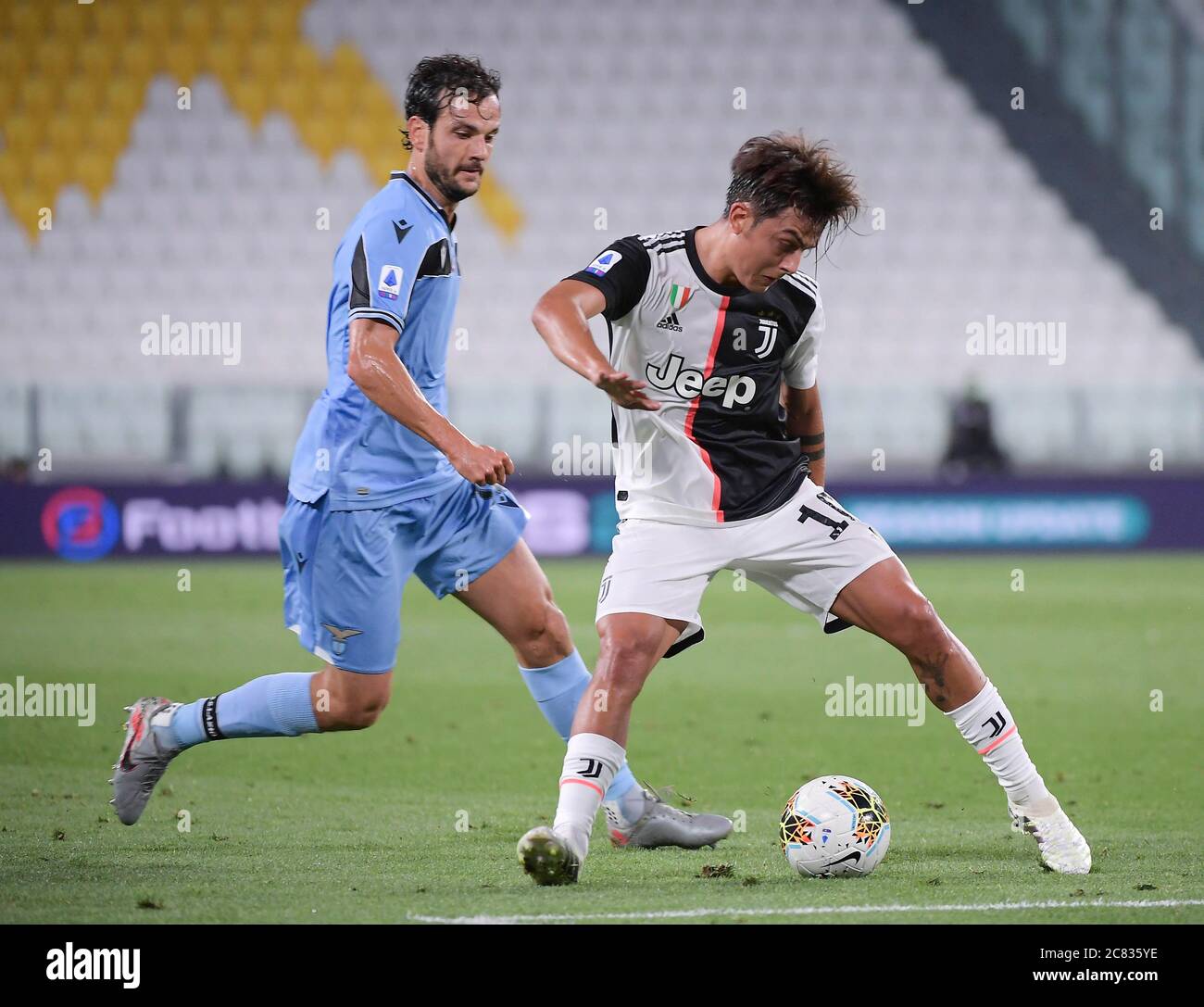 Turin, Italy. 20th July, 2020. FC Juventus' Paulo Dybala (R) vies with Lazio's Marco Parolo during the Serie A football match in Turin, Italy, July 20, 2020. Credit: Federico Tardito/Xinhua/Alamy Live News Stock Photo