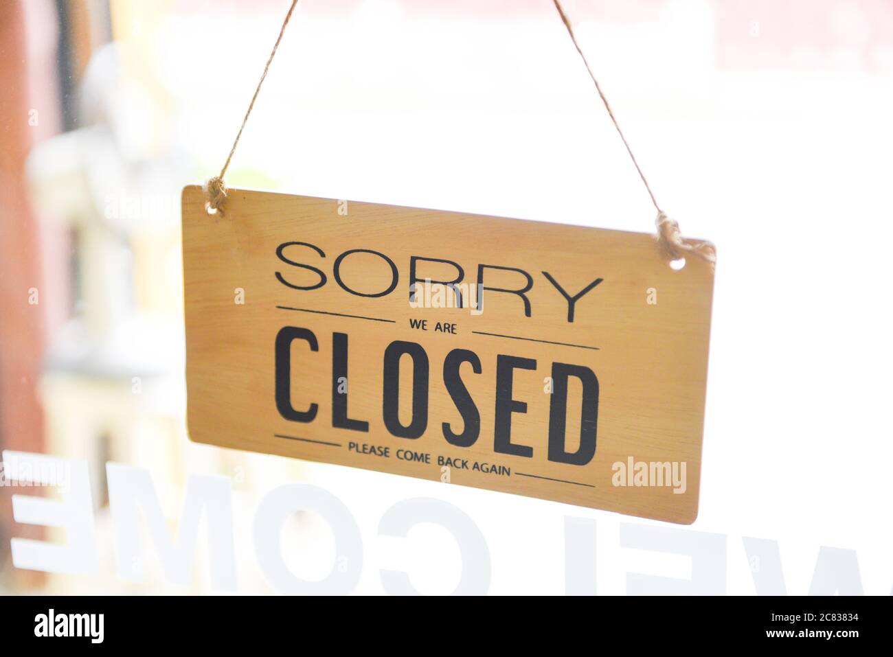 Closed shop sign / Sorry we're closed sign hanging on cafe glass door Stock Photo