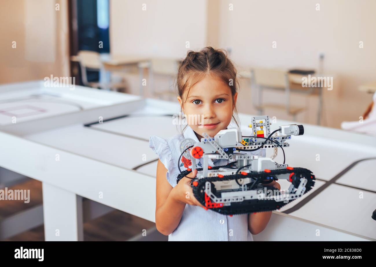Schoolgirl holding constructor robot in robotics class Stock Photo