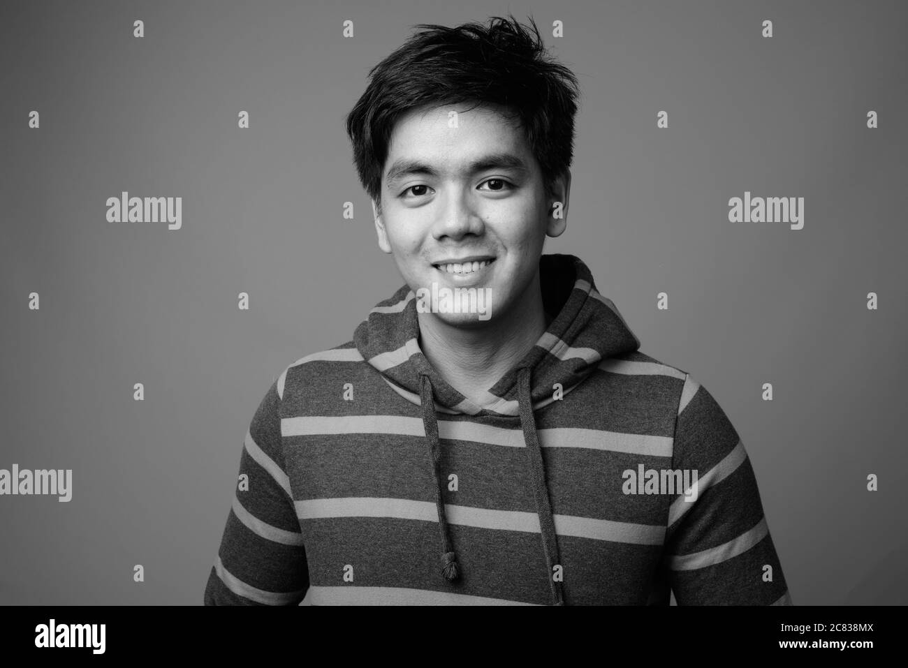 Portrait of young handsome Filipino man wearing hoodie Stock Photo