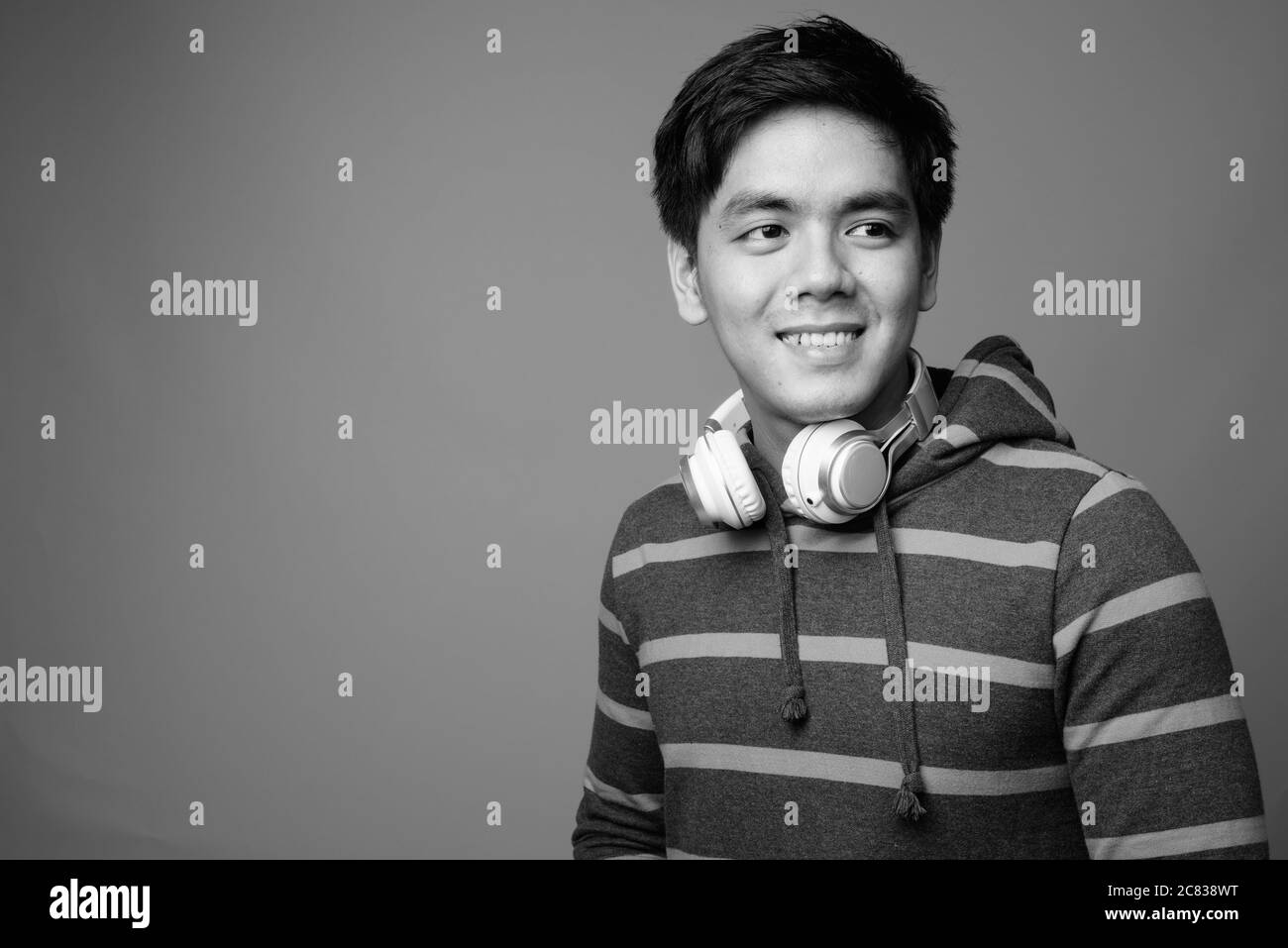 Portrait of young handsome Filipino man wearing hoodie Stock Photo