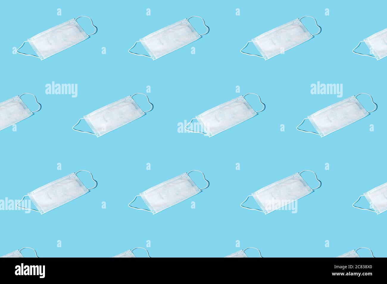 Trendy pattern from protective masks with soft shadow. Clean surgical mask. Isometric pattern on blue background Stock Photo