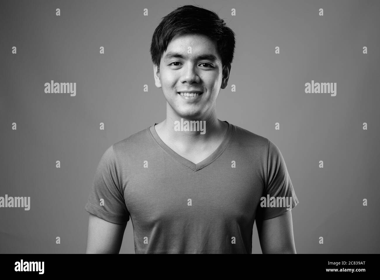 Portrait of young handsome Filipino man against gray background Stock Photo