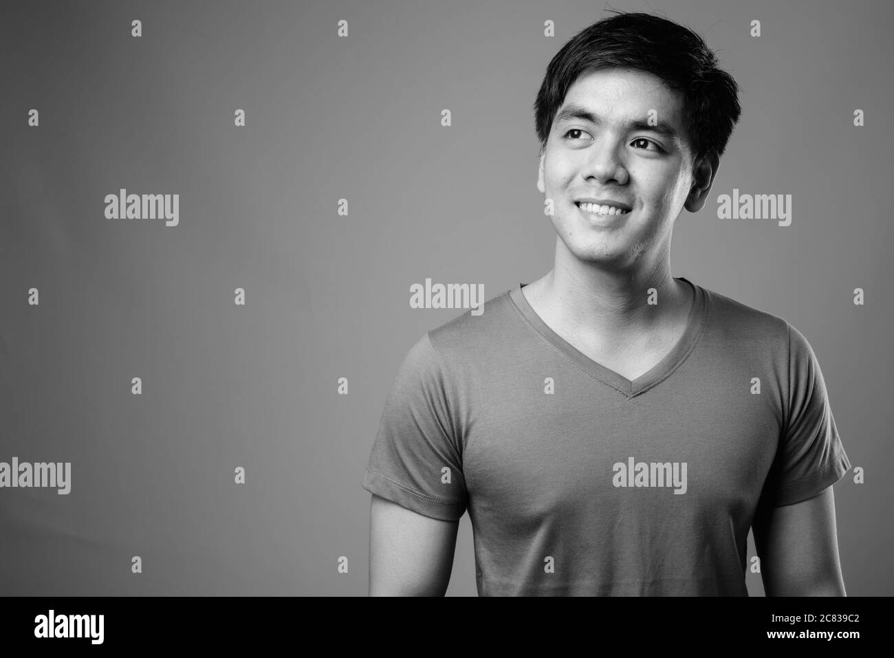 Portrait of young handsome Filipino man against gray background Stock Photo