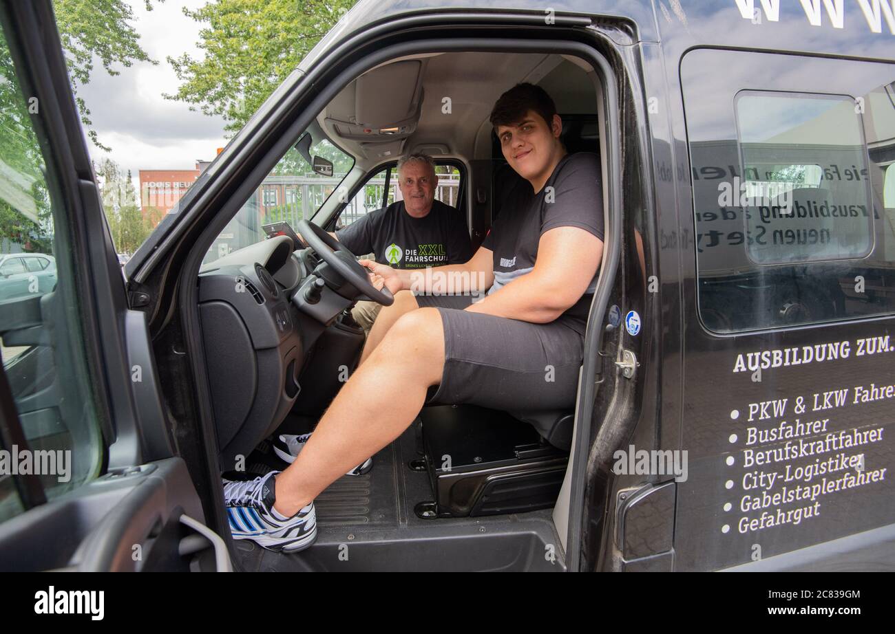 Hanover, Germany. 20th July, 2020. Jannik Könecke (r) and Jörg Vespermann,  driving instructor and managing director of Berufskraftfahrer-Akademie-Nord  GmbH, sit in the specially converted van. Jannik Könecke is 2.24 metres  tall and