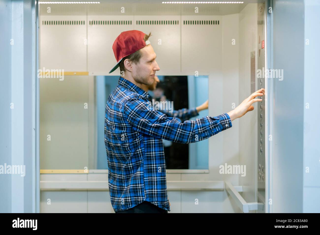 a young man in casual come inside the lift elevator cabin Stock Photo