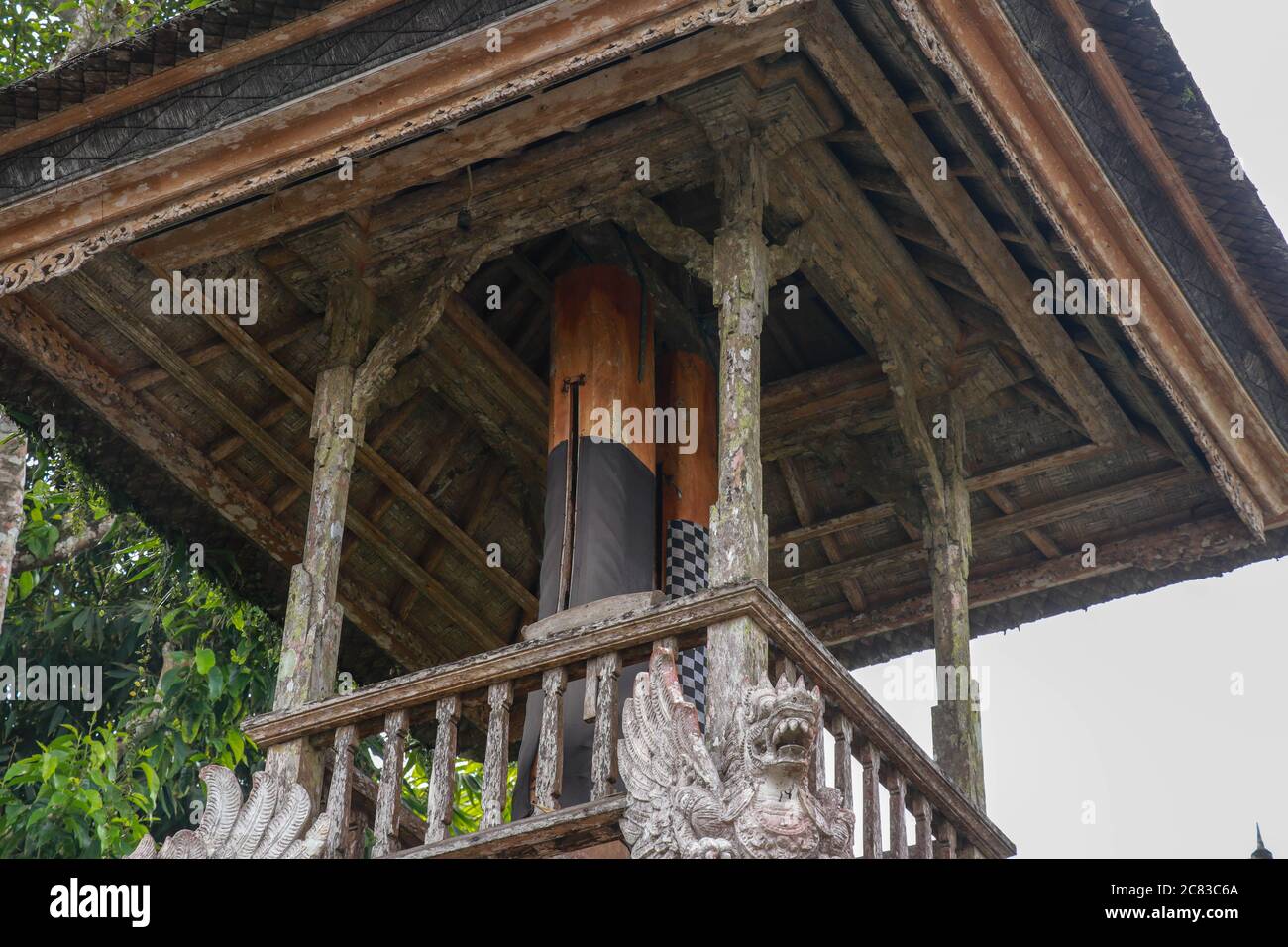 Wooden bell with a mallet made from a tree trunk. Bale Kulkul is building to hand up the traditional alarm for local Balinese people when they are Stock Photo