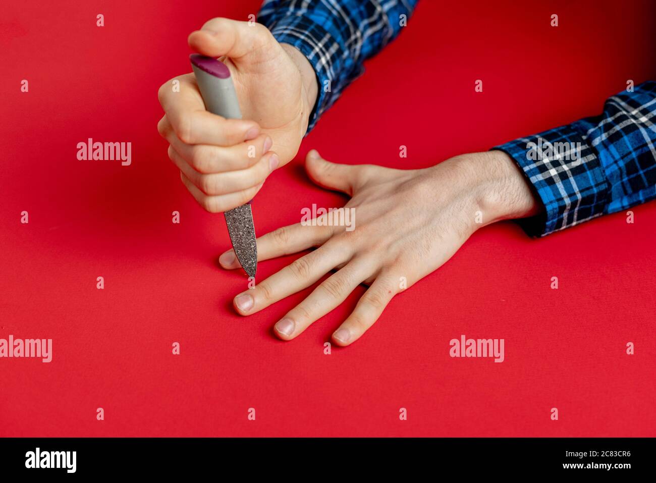 hand with knife hitting between the fingers on the table, playing the