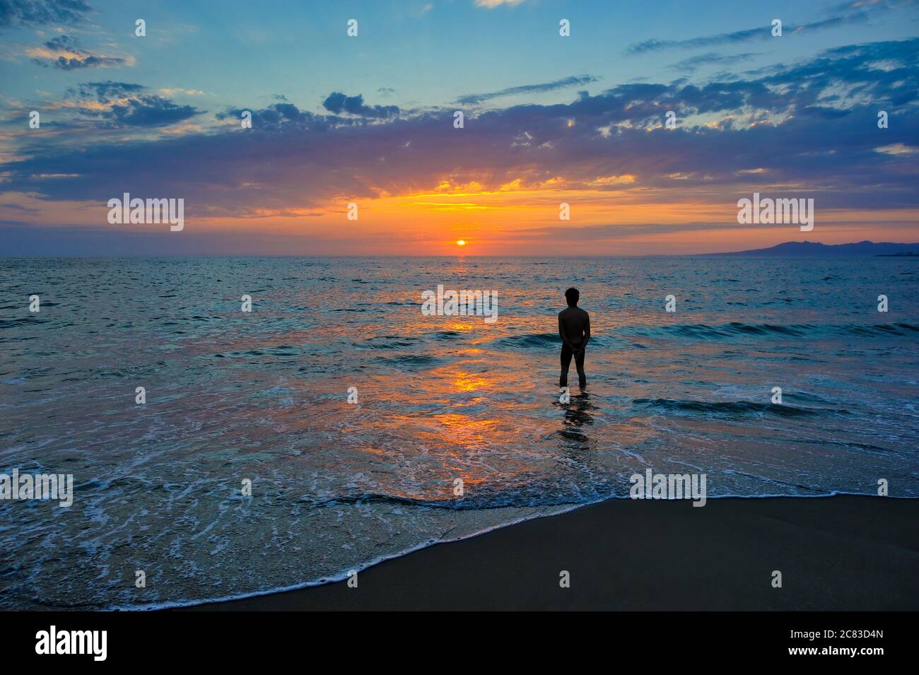 A Single Man Stands Peacefully Watching the Ocean Sunrise Stock Photo ...