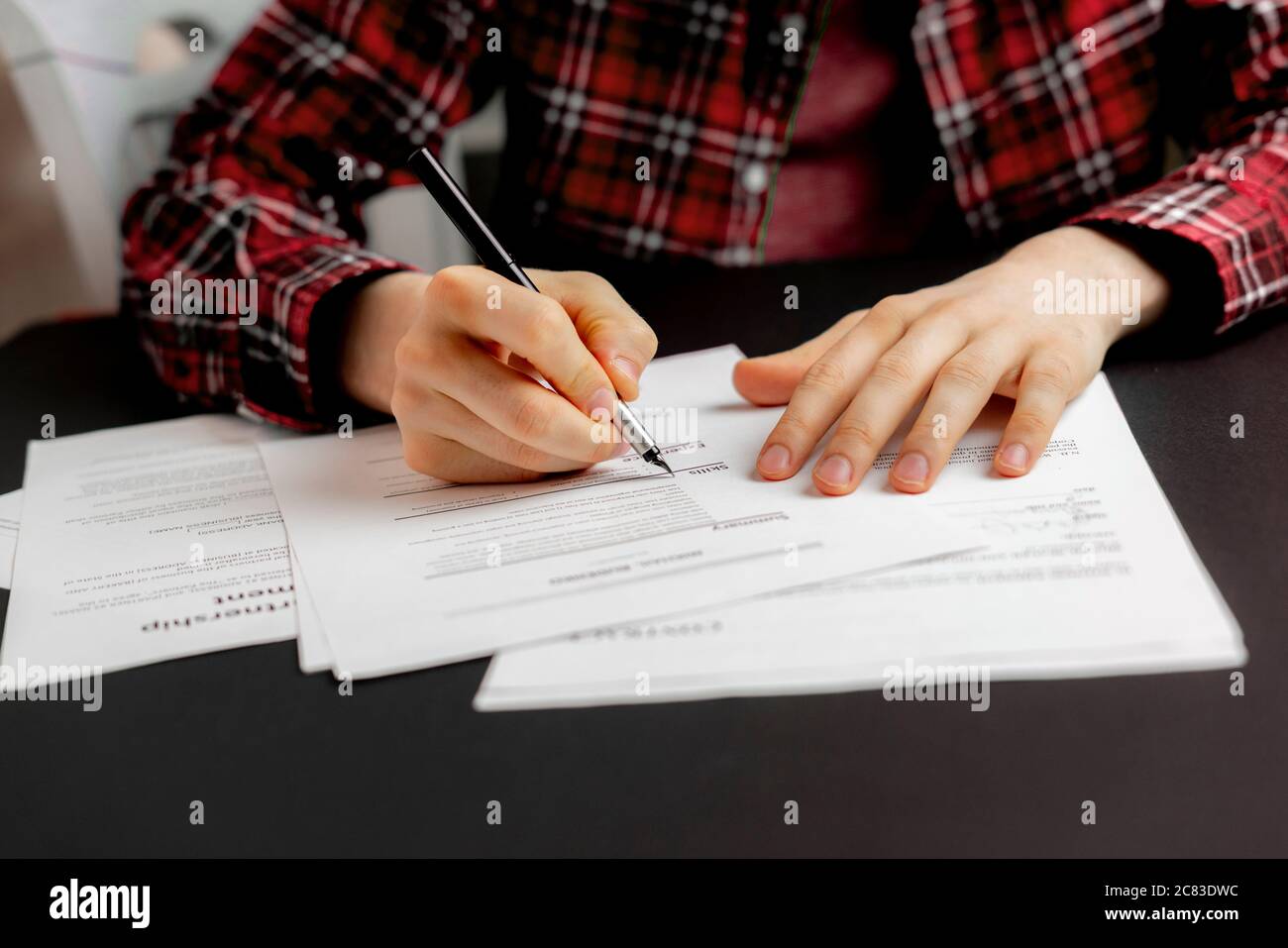 a person's hand holding a pen and sign the document contract in office, agreement success concept Stock Photo