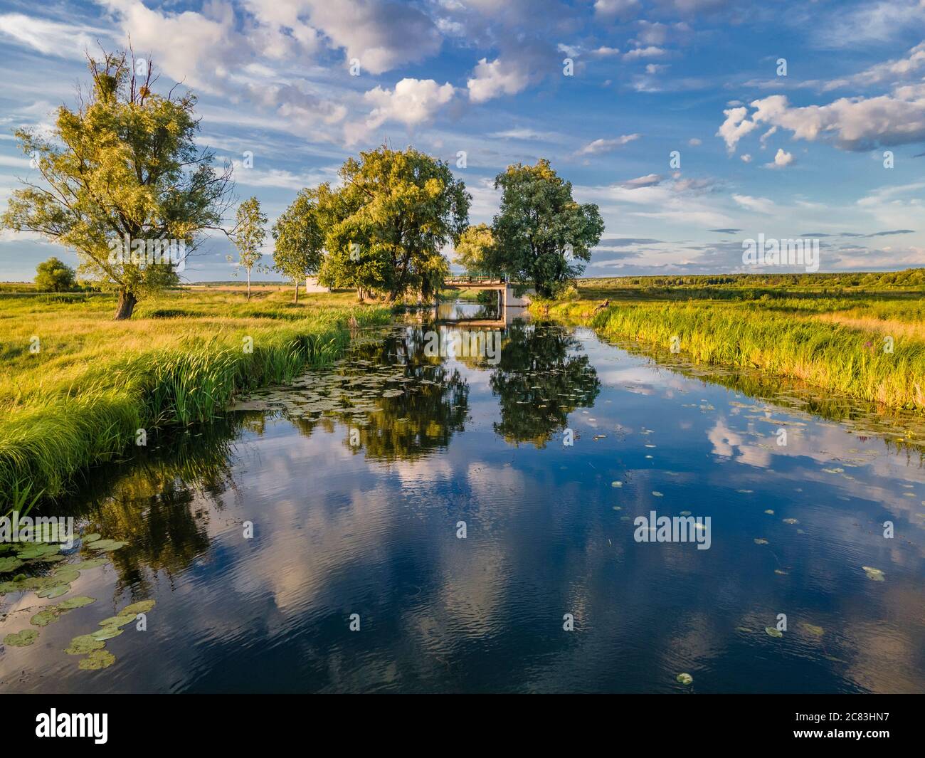Amazing small river with blue sky and clouds reflection on water. Summer countryside scene. Fishermans dream Stock Photo