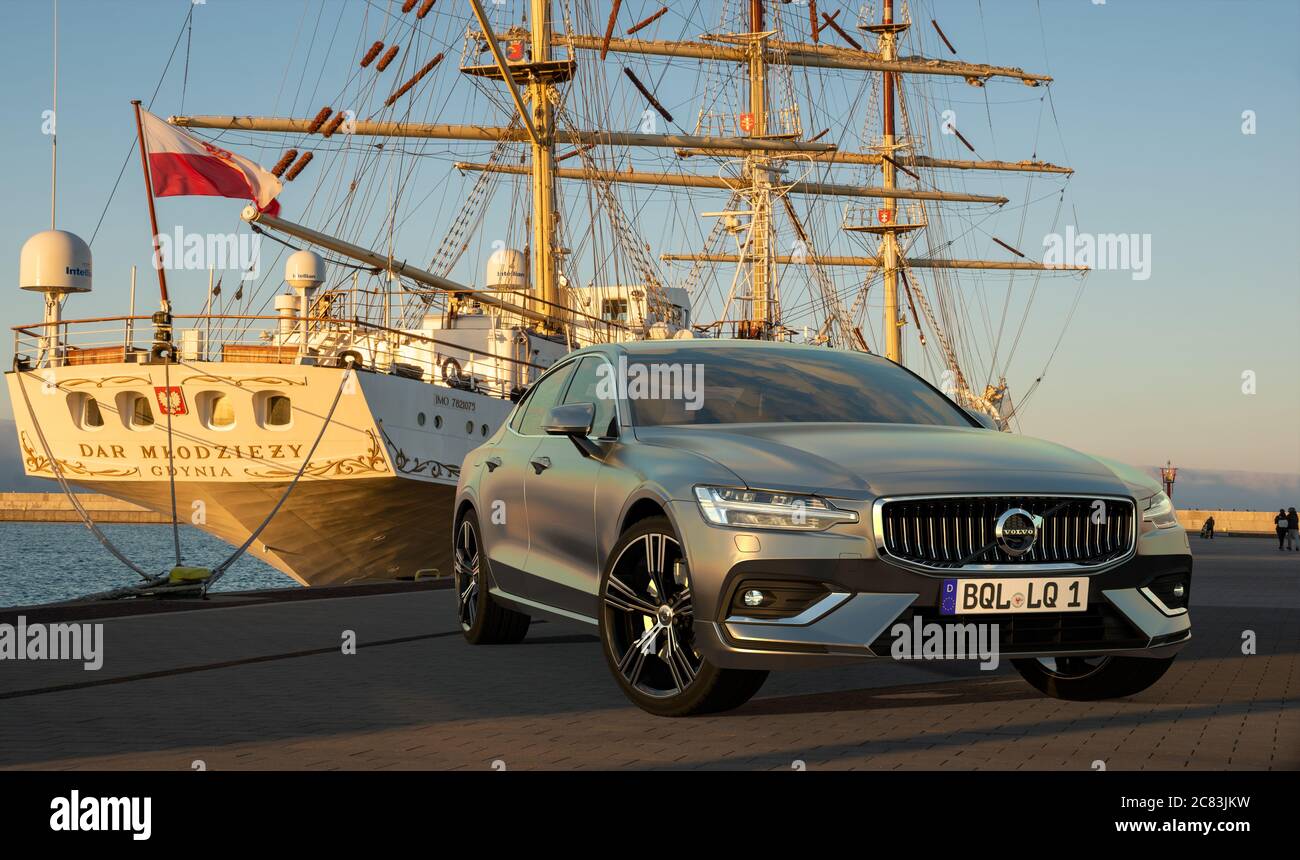 New Volvo S60 on the background of a sailing ship Stock Photo