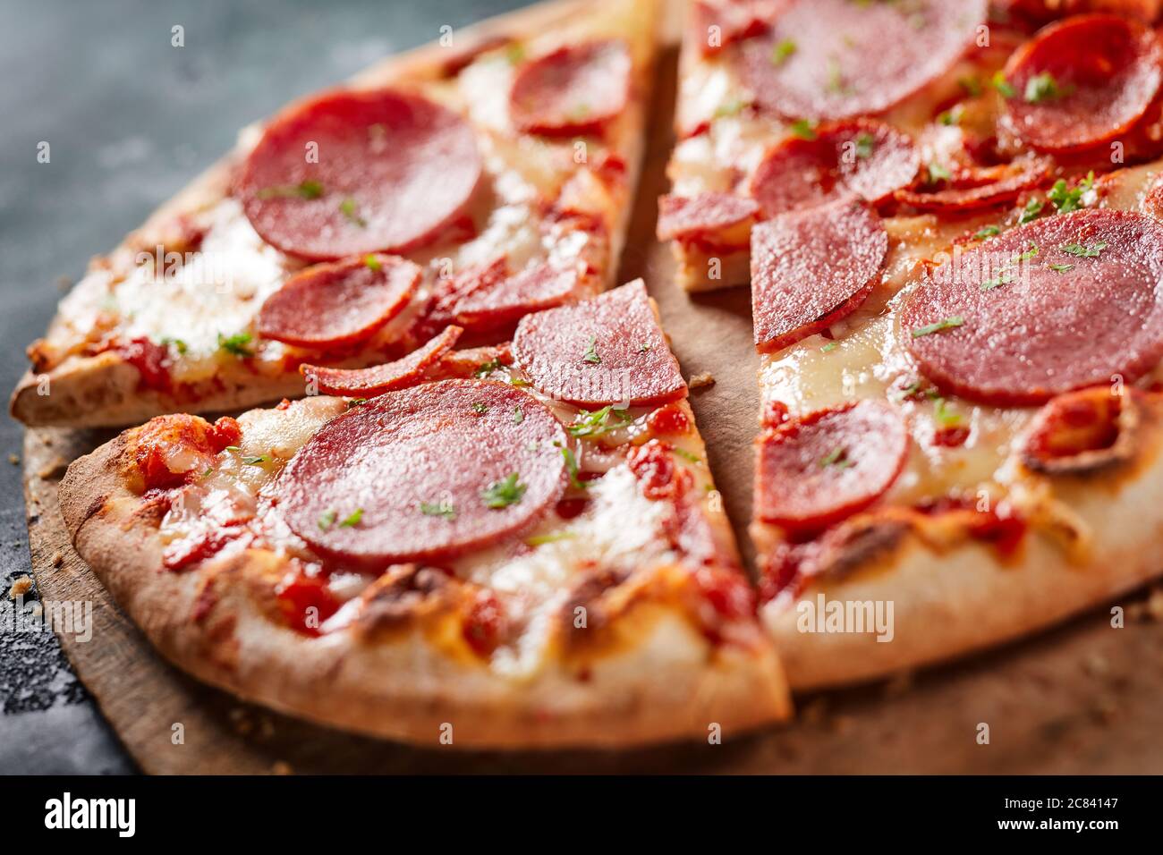 Traditional Italian salami pizza in close up on a crispy oven fired base with mozzarella cheese and tomato Stock Photo
