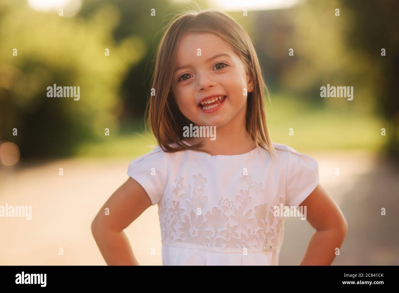 Portrait of happy smiled little girl in white dress Stock Photo - Alamy