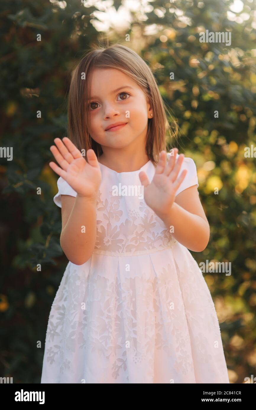 Portrait of happy smiled little girl in white dress Stock Photo - Alamy