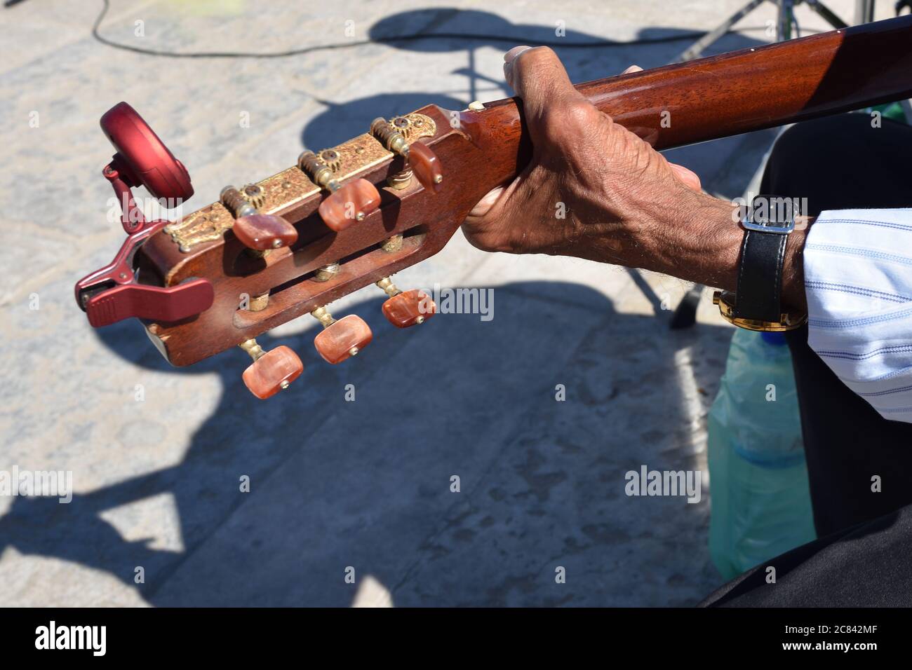 Hand of a senior street musician on a guitar fingerboard during street show on the square Praca de Comercio (Commerce square), Lisbon, Portugal Stock Photo