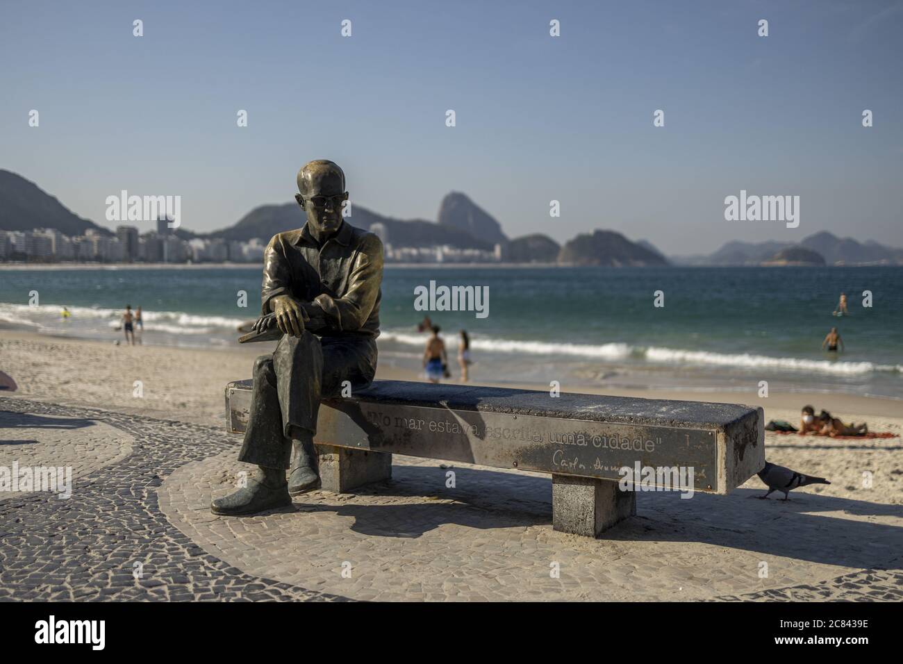 RIO DE JANEIRO, BRAZIL - Jul 12, 2020: Statue of Brazilian poet Carlos Drummond de Andrade on a Copacabana bench with quote 'In the ocean a city was w Stock Photo