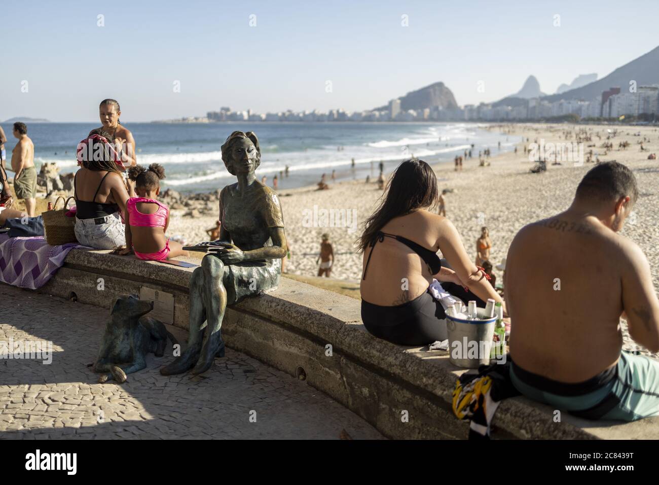 RIO DE JANEIRO, BRAZIL - Jul 12, 2020: Copacabana boulevard and beach with people around the bronze statue of Clarice Lispector, Ukranian journalist a Stock Photo