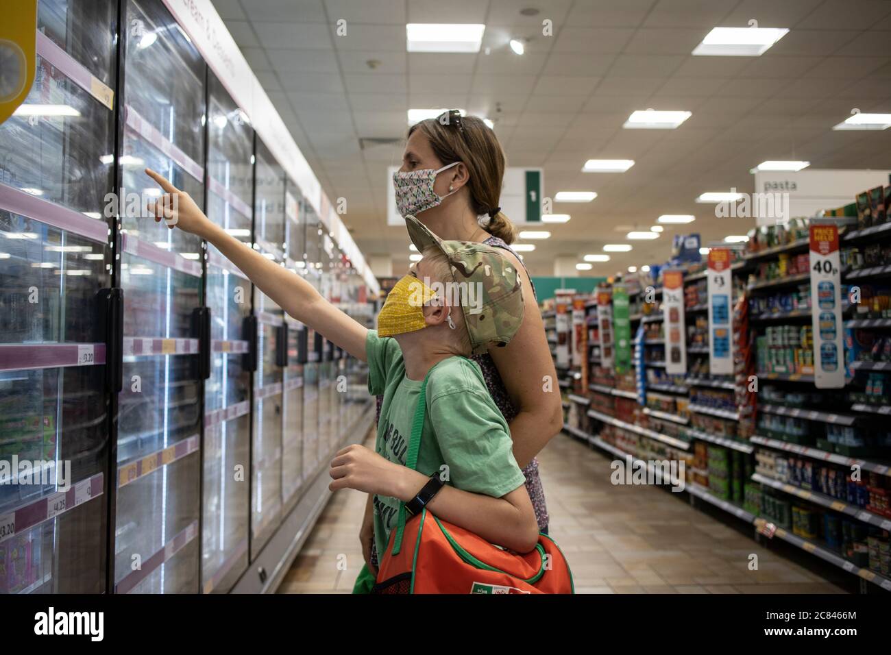 Family shopping in Morrisons UK supermarket wearing protective facemarks to protect against the spread of infection of coronavirus, London, England UK Stock Photo