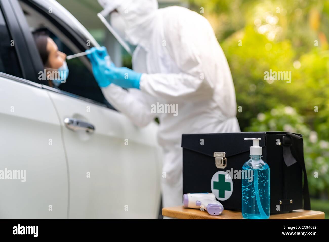 COVID-19 Test kit for Drive Thru station in hospital with background of medical staff with PPE suit test to patience by throat swab. New normal health Stock Photo