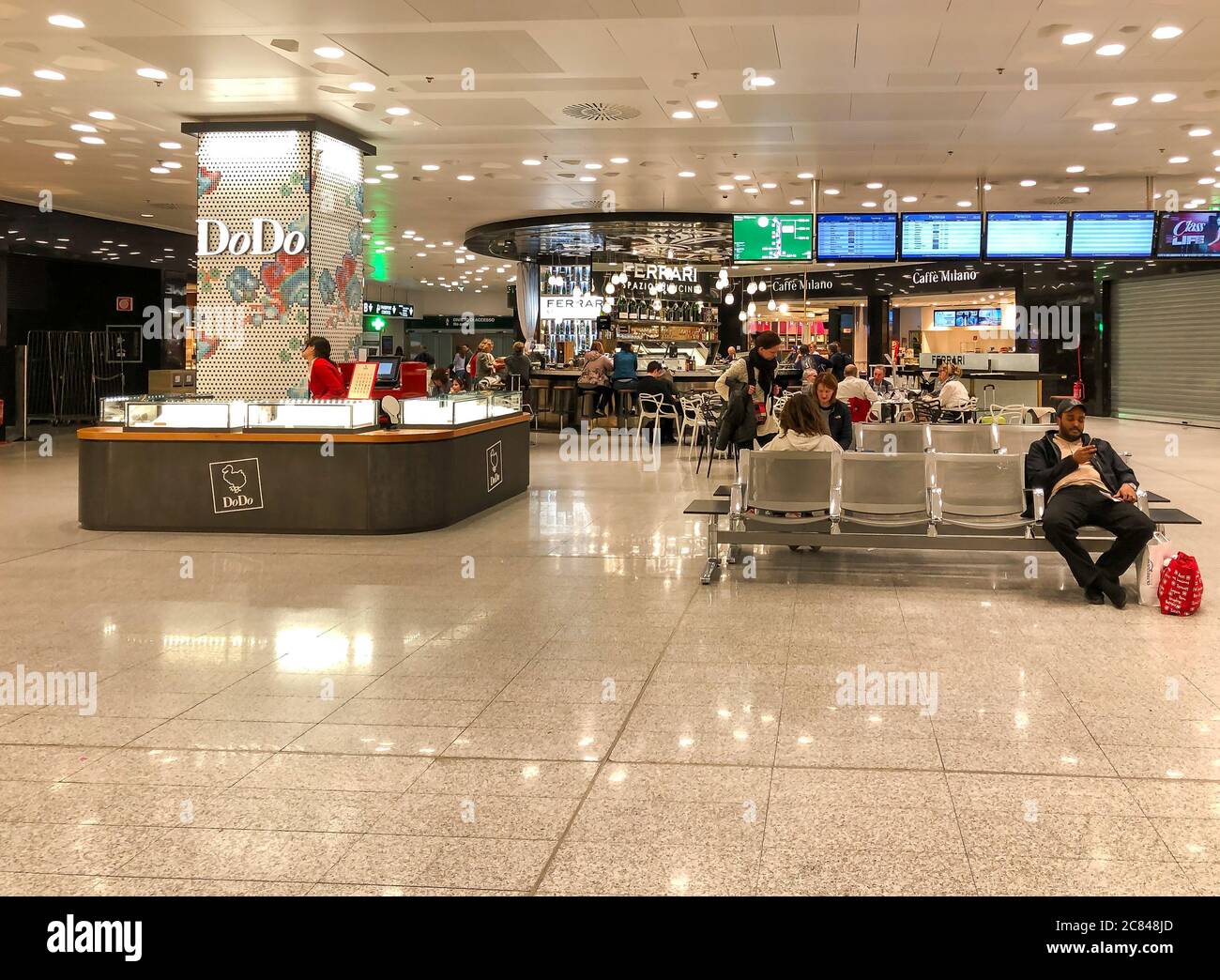 Ferno, Milan-Malpensa, Italy - February 8, 2020: Interiors with shops and bars in the Terminal 1 of Milan-Malpensa International Airport. Stock Photo