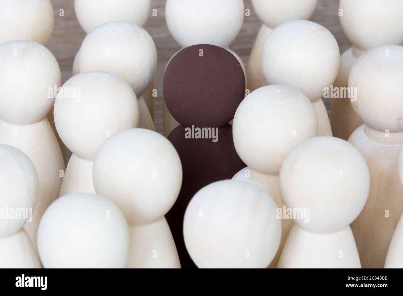 A racial harmony concept of a single black person standing in a crowd of white people Stock Photo