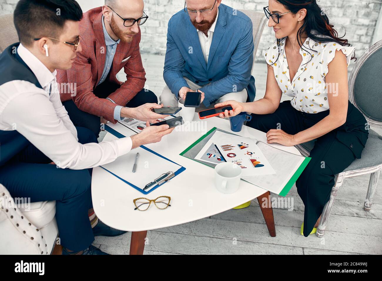 Male and female diverse hands holding cell phones, multiracial business people using smartphones applications software, users and devices concept Stock Photo