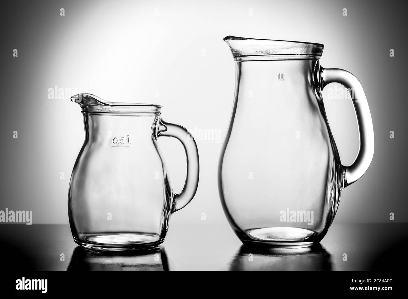 Two empty water jugs against illuminated background Stock Photo Alamy