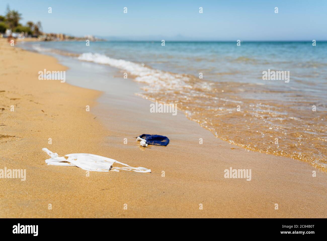 Beach polluted with face masks of covid. Environmental contamination problem Stock Photo