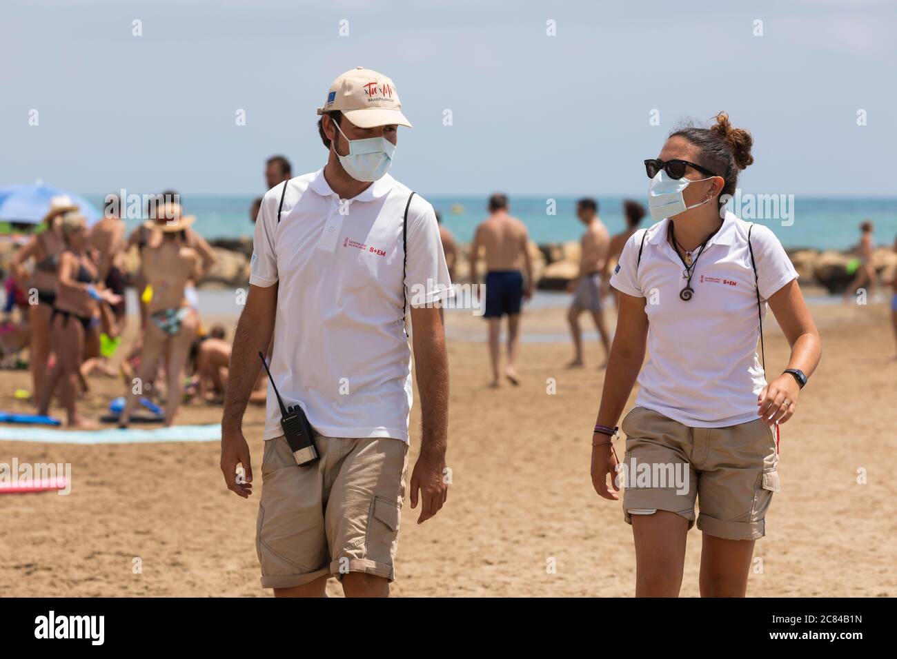 Torrenostra, Castellon, Spain - July 16, 2020: Beach assistants and attendants, work on the beach informing to help beachgoers to prevent coronavirus. Stock Photo