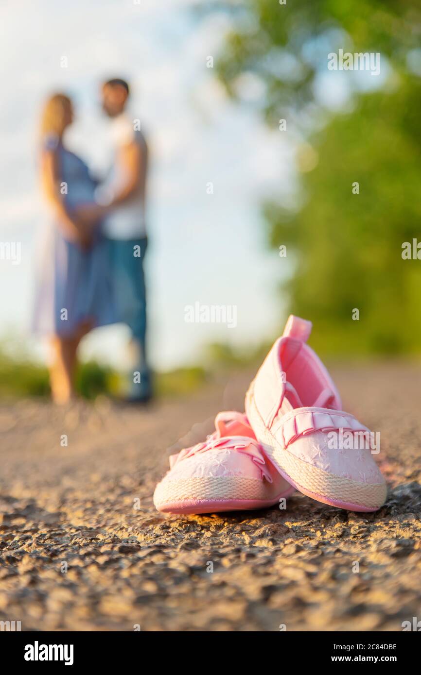 Pregnant woman and man baby shoes. Selective focus. nature Stock