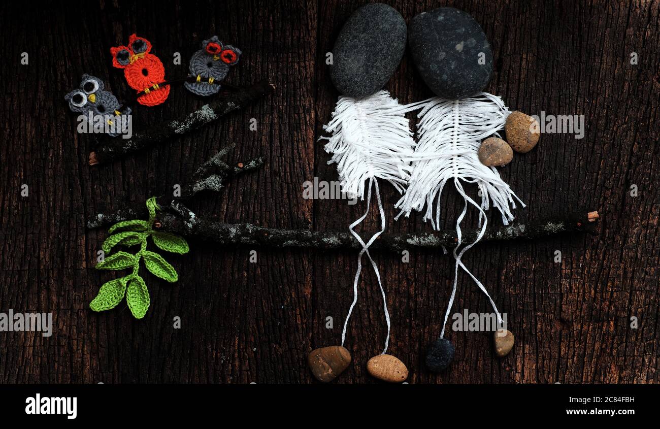 cute concept with joke for love concept background, couple as skeleton from macrame sit on branch of tree, head from pebble so art, happy fall in love Stock Photo